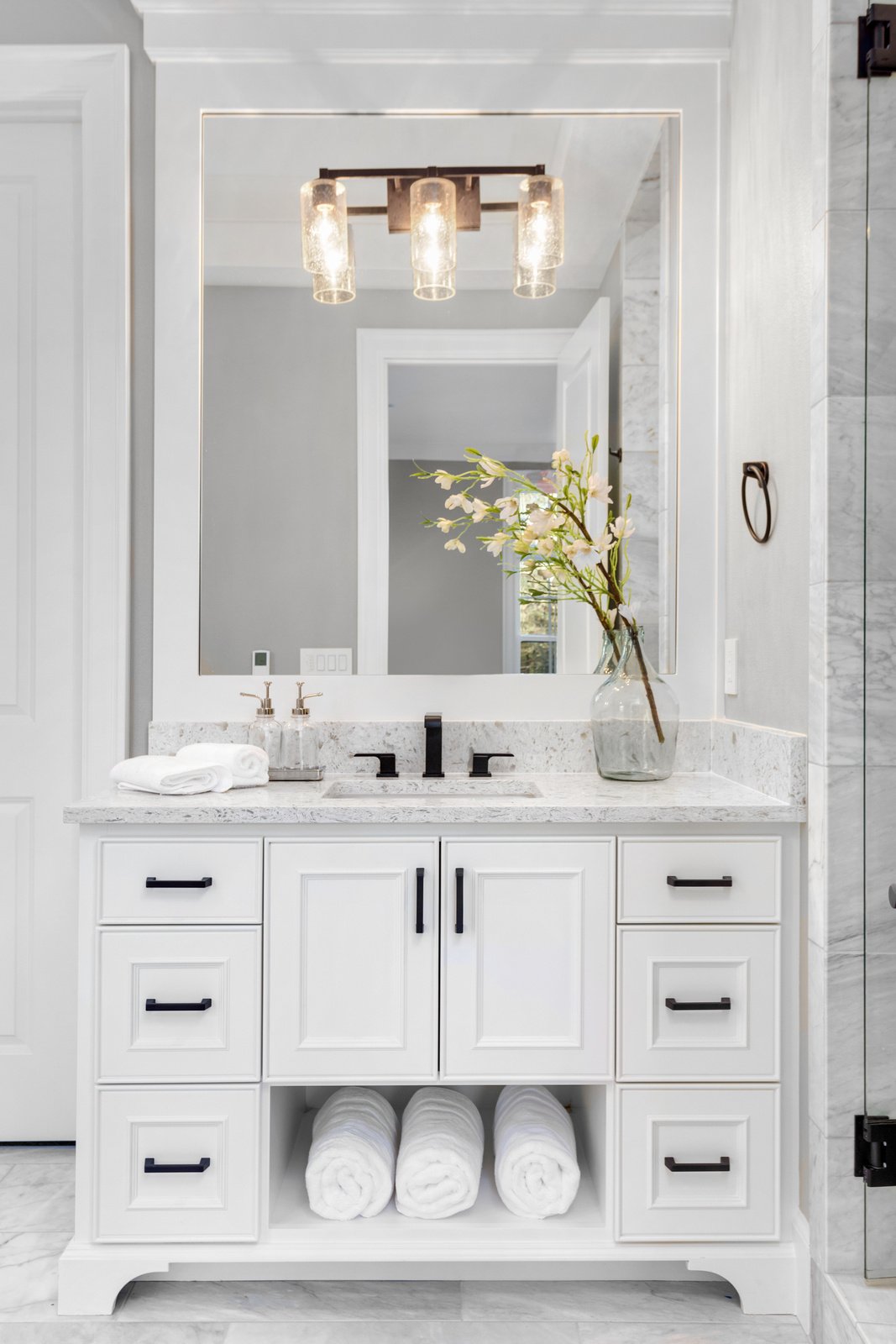 Beautiful bathroom interior in new luxury home with vanity, mirror, and cabinets